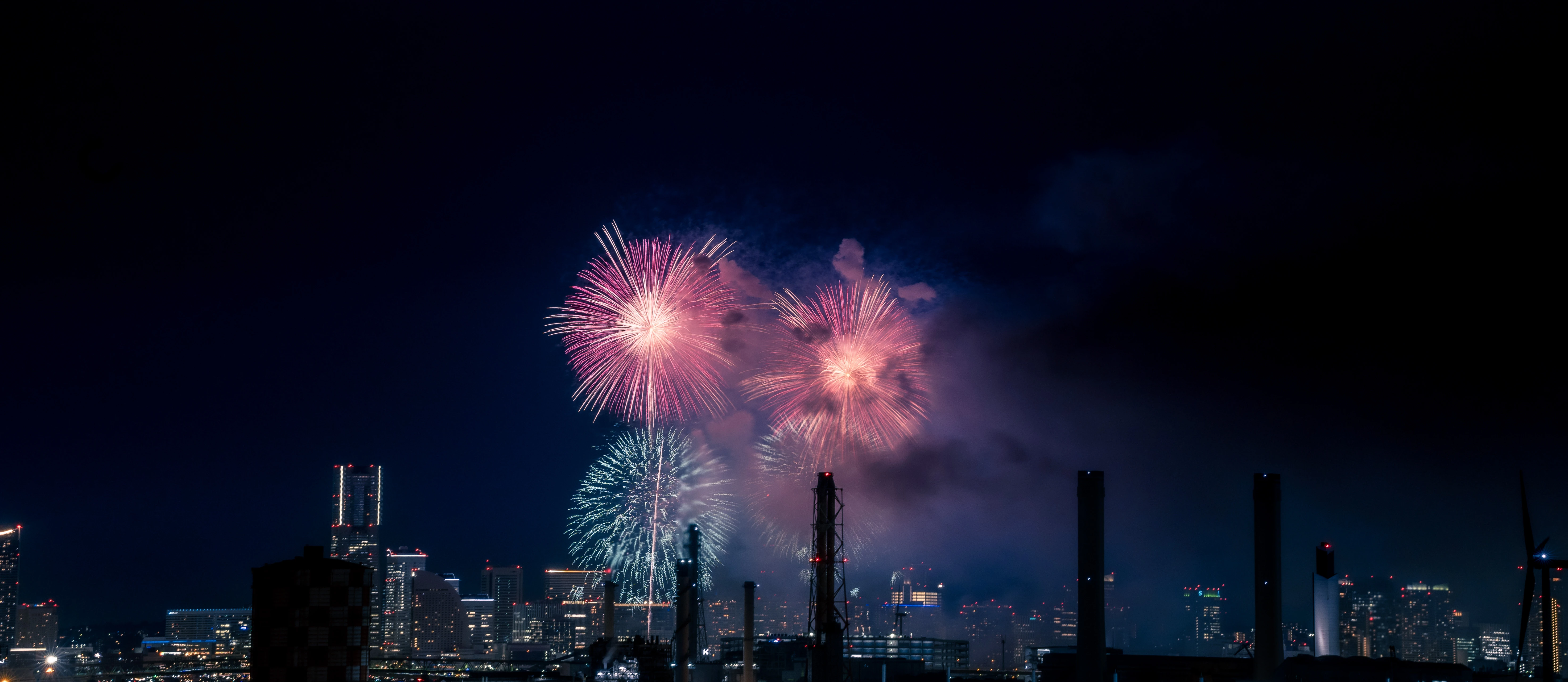 Vibrant Fireworks Over a Nighttime Urban Skyline